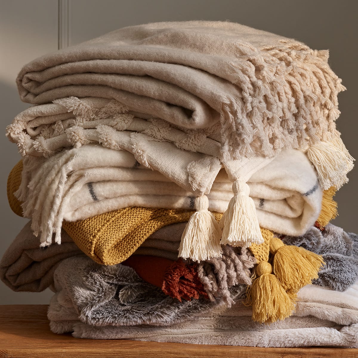 Pile of throws in various colours 