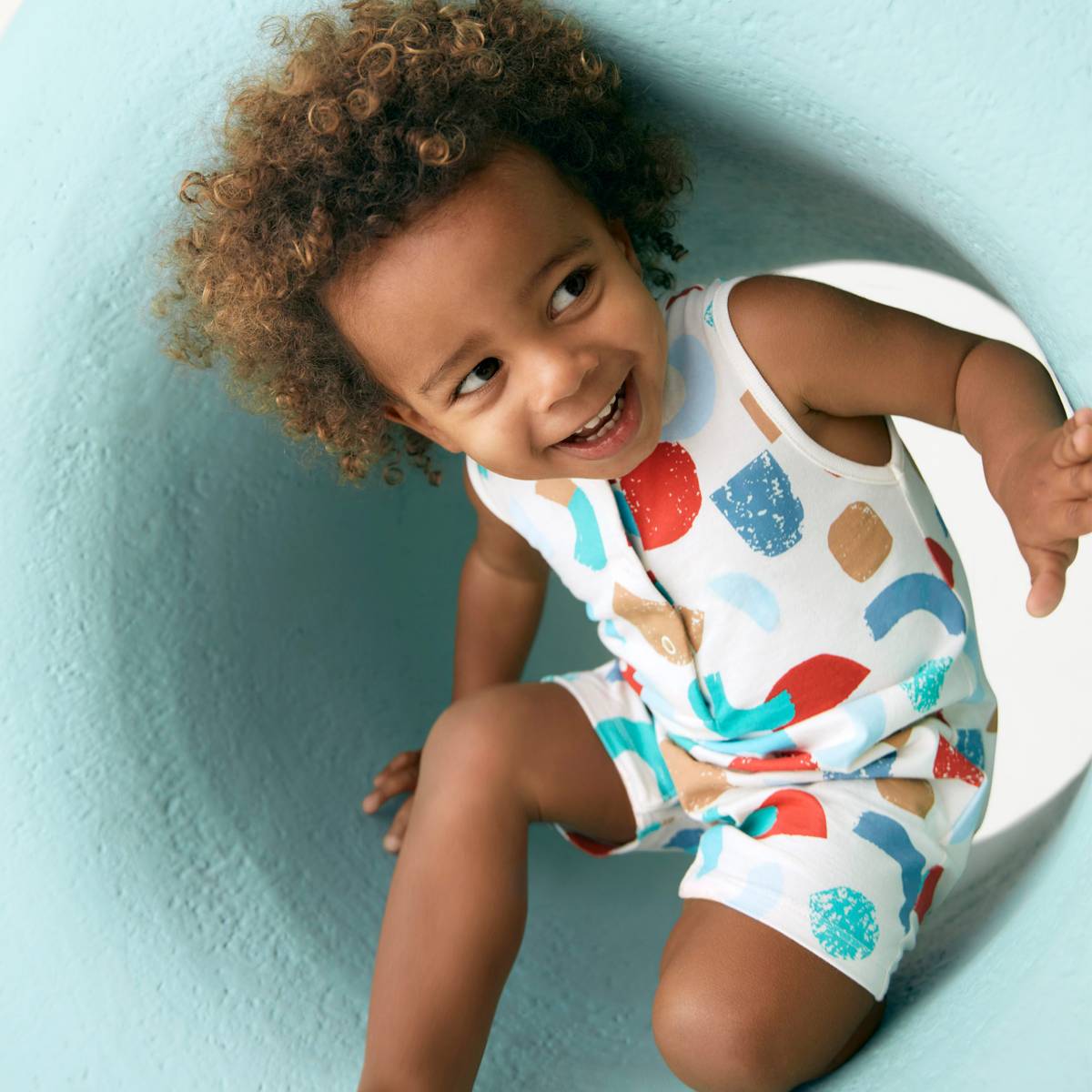 תינוק לובש אוברול ללא שרוולים עם הדפס